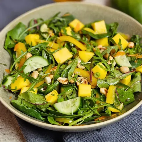 Fruchtiger Rucola-Salat mit Mango, Gurke und gerösteten Erdnüssen