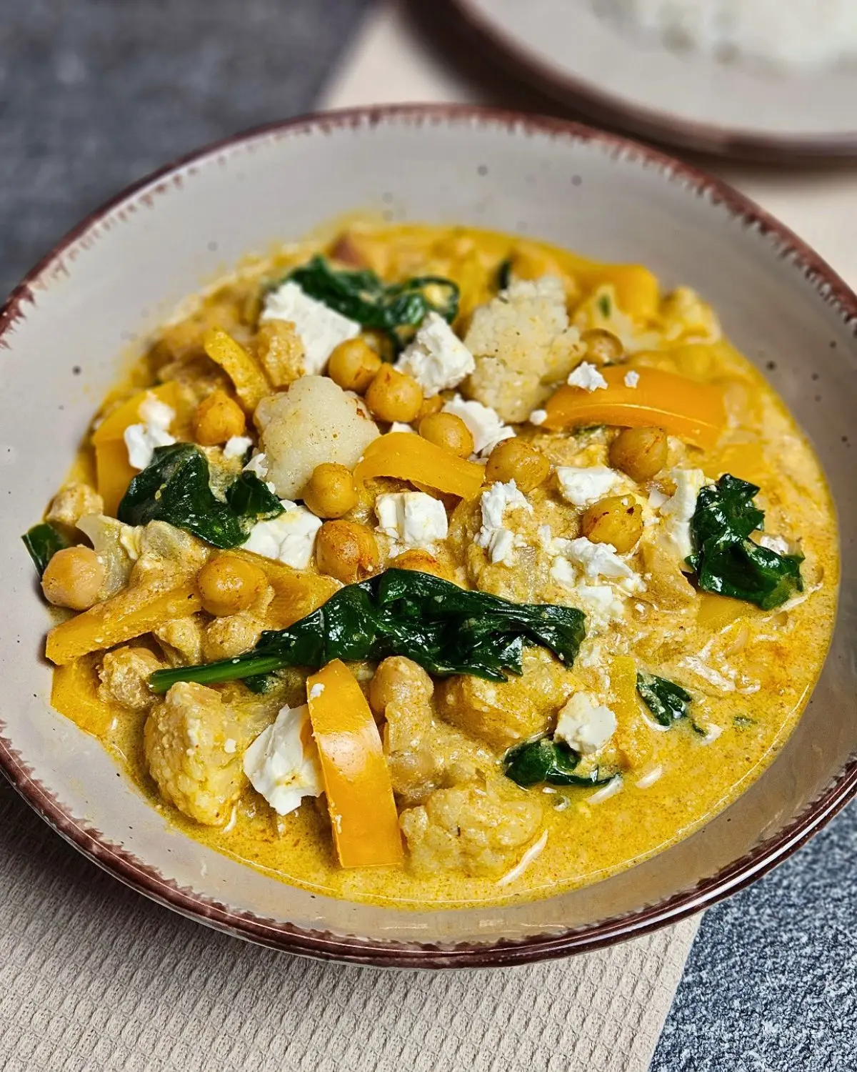 Kichererbsen Curry mit Feta und Spinat in einer Schüssel angerichtet