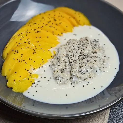 Overnight Oats mit Mango und Protein-Kokos-Creme auf einem Teller angerichtet