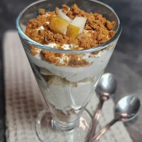 Skyr mit Birne und Karamellcrumble in einem hohen Glas geschichtet