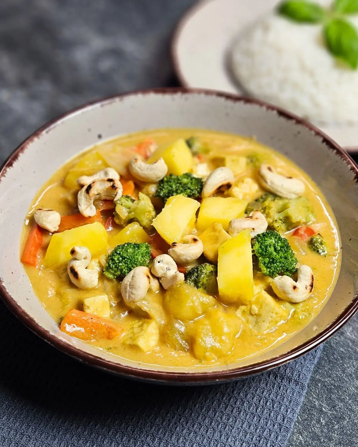 Veganes Mango-Curry mit Tofu und Brokkoli auf einem Teller