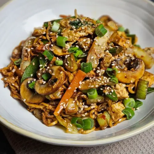 Vegetarisches Bami Goreng mit Tofu und Mie Nudeln auf einem Teller angerichtet