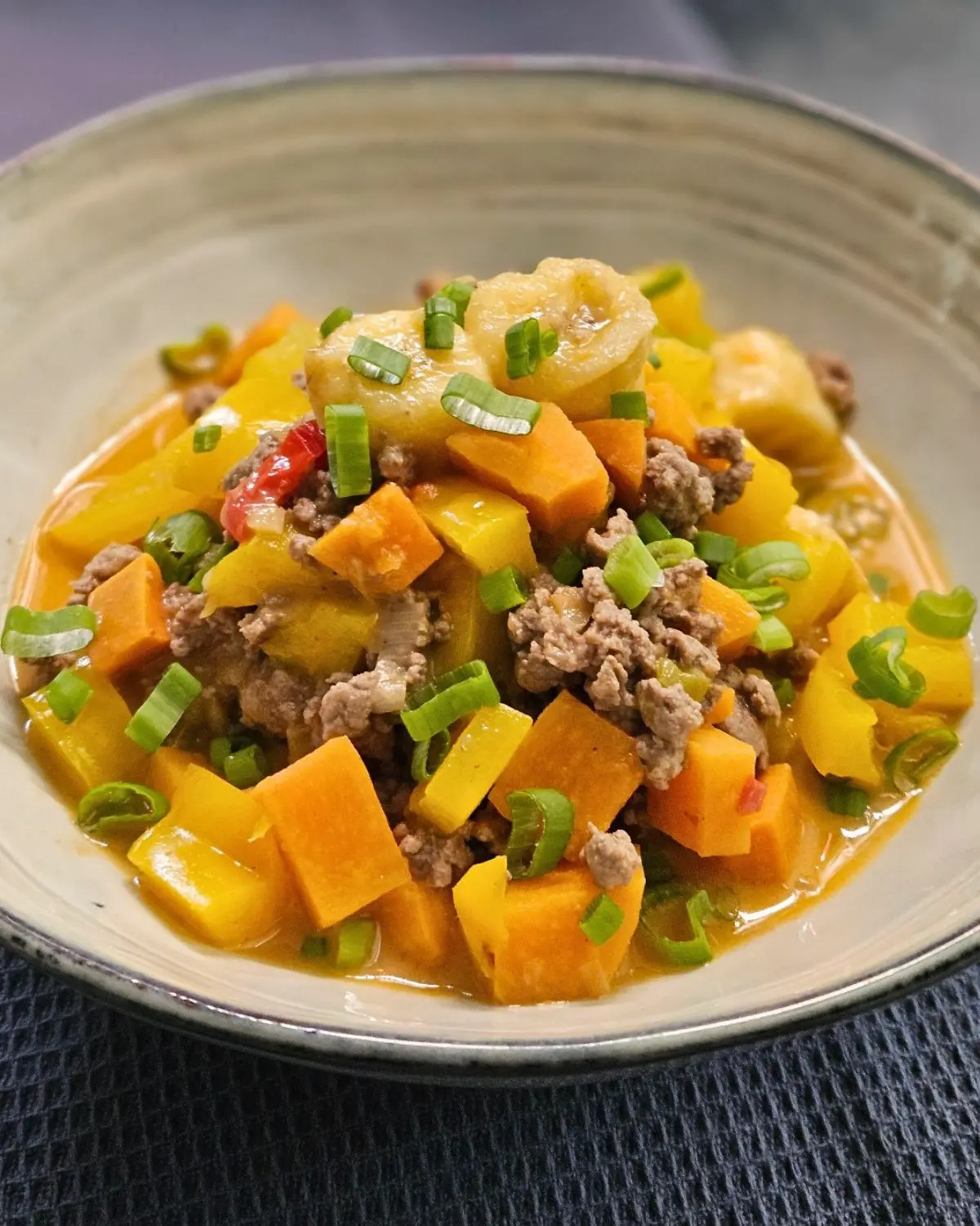 Karibisches Hackfleisch-Curry mit Banane und Süßkartoffel in einer Schüssel angerichtet