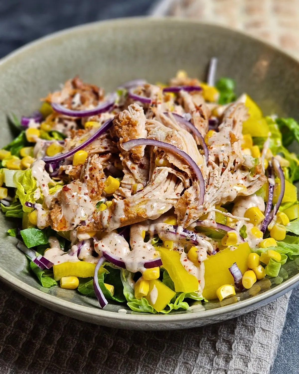 Pulled Chicken Salat mit BBQ-Joghurt-Dressing in einer Schüssel angerichtet