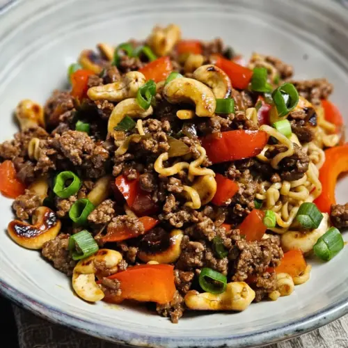 Asiatische Hackfleischpfanne mit Cashews und Mie-Nudeln in einer Schüssel angerichtet