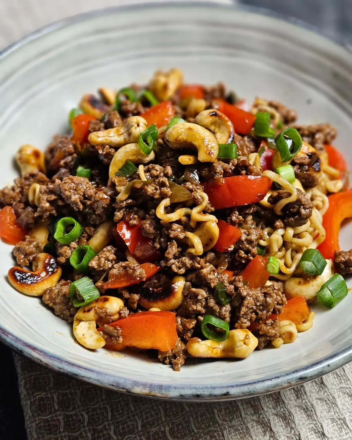 Asiatische Hackfleischpfanne mit Cashews und Mie-Nudeln in einer Schüssel angerichtet