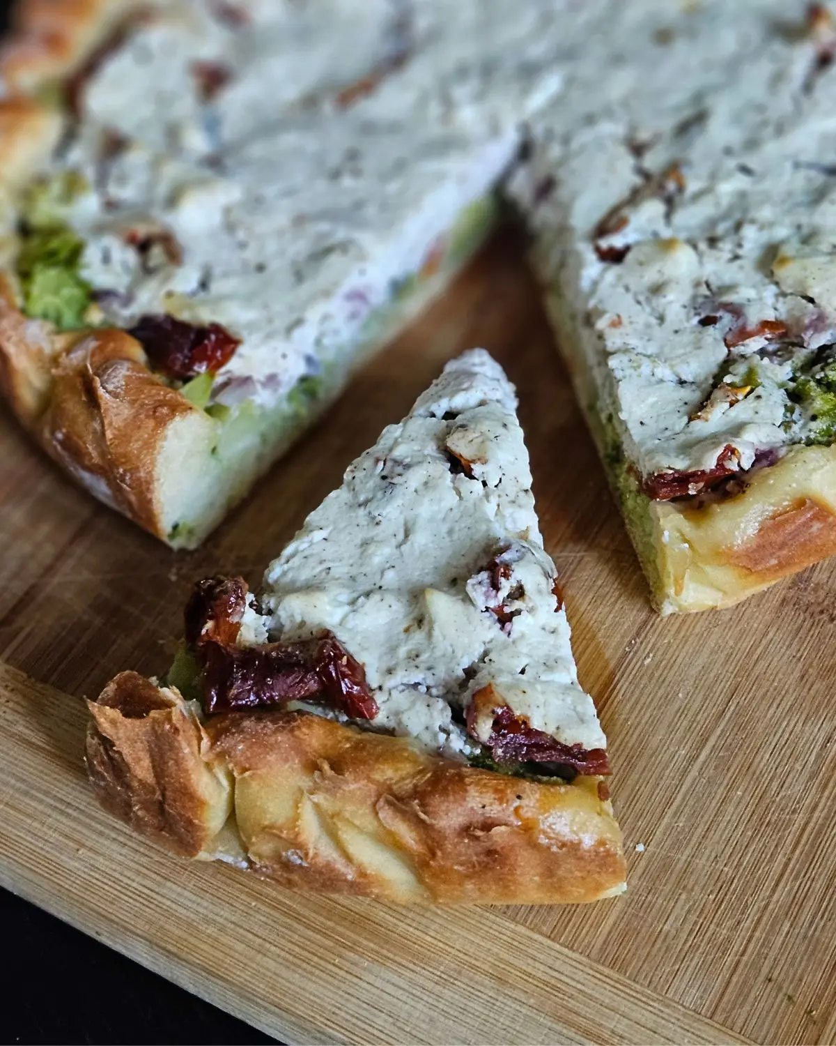 High Protein Brokkoli-Quiche mit Quarkteig angeschnitten auf einem Brett angerichtet
