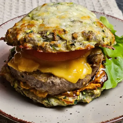 Low Carb Burger mit Zucchini-Käse-Bun auf einem Teller angerichtet