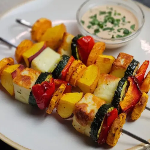 Halloumi-Pfirsich-Spieße mit Pfirsich-Chili-Sauce - Airfryer Edition, drei Spieße mit einer Schale Sauce auf einem Teller angerichtet