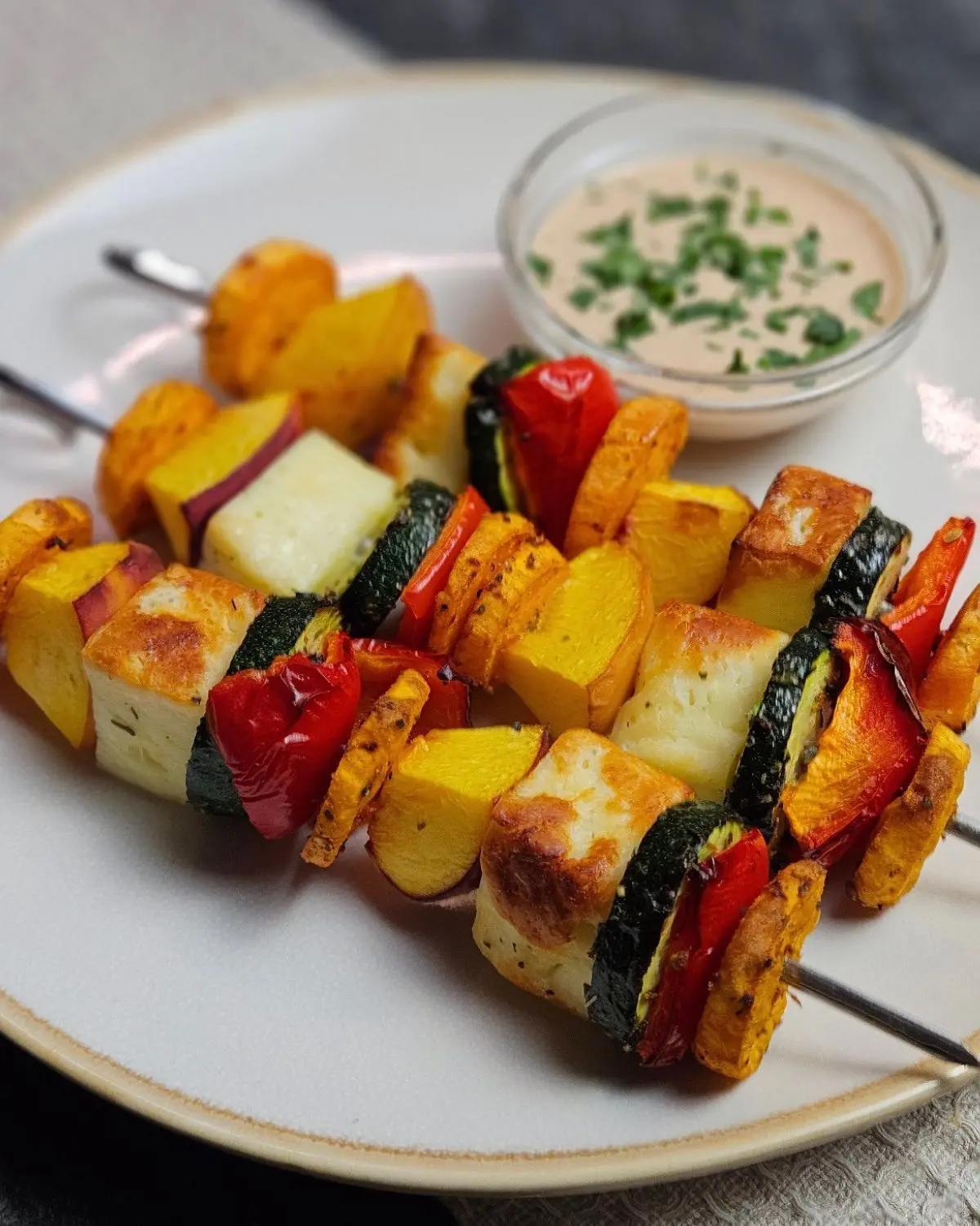 Halloumi-Pfirsich-Spieße mit Pfirsich-Chili-Sauce - Airfryer Edition, drei Spieße mit einer Schale Sauce auf einem Teller angerichtet