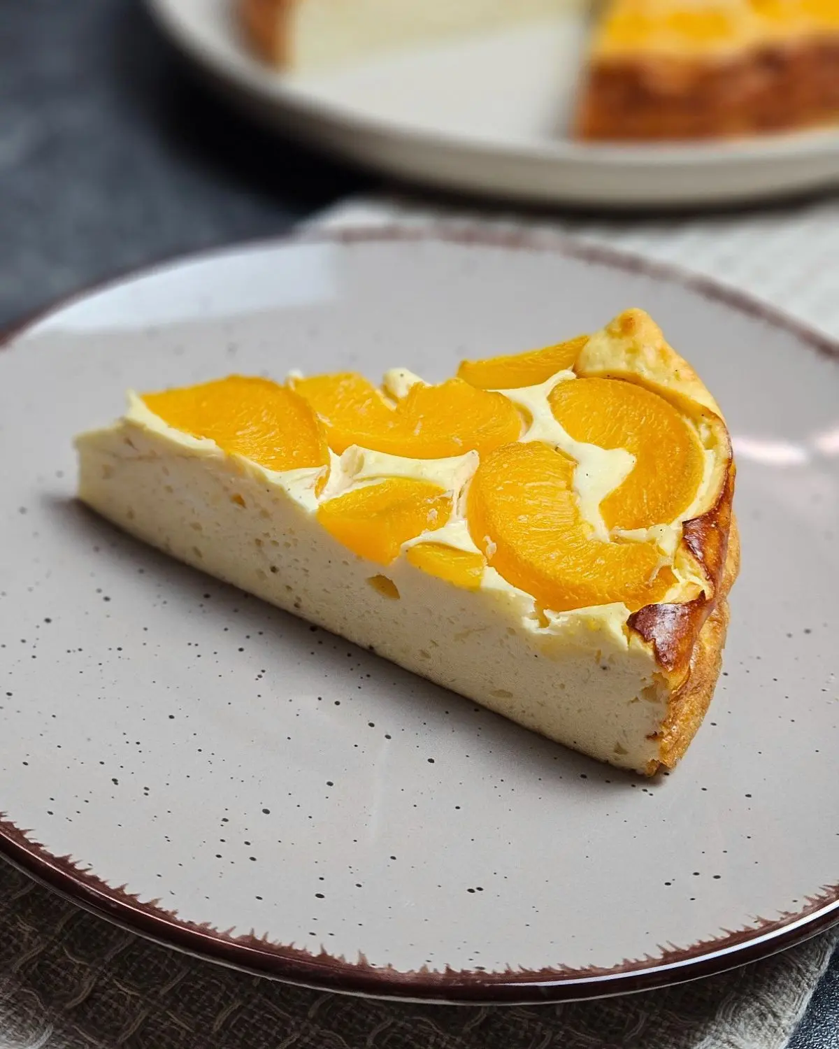 High Protein Aprikosen-Käsekuchen, ein Stück auf einem Teller serviert