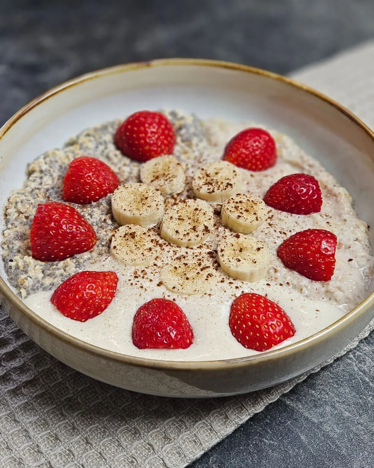 High Protein Frühstücksbowl mit Buchweizen, Banane und Erdbeeren in einer Bowlschüssel angerichtet