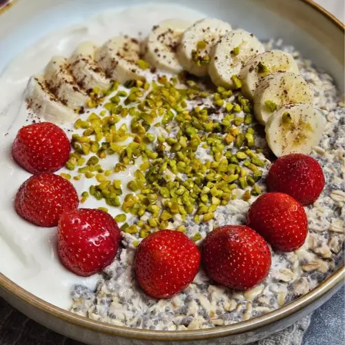 High Protein Haferflocken-Bowl mit Banane und Erdbeeren in einer Bowl angerichtet