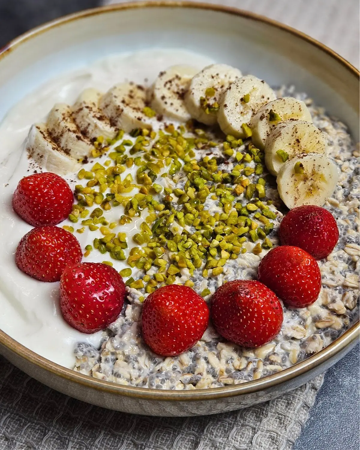 High Protein Haferflocken-Bowl mit Banane und Erdbeeren in einer Bowl angerichtet