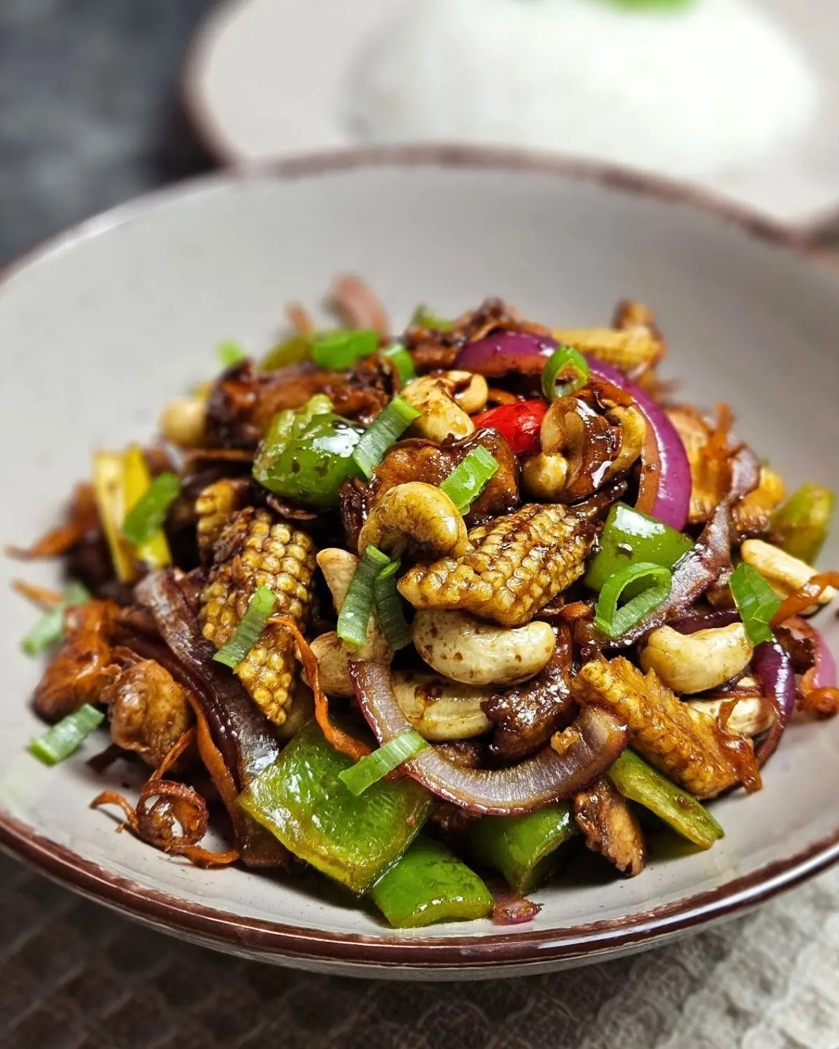 Thailändisches Cashew-Hähnchen mit Gemüse und einer Portion Reis in einer Schüssel angerichtet
