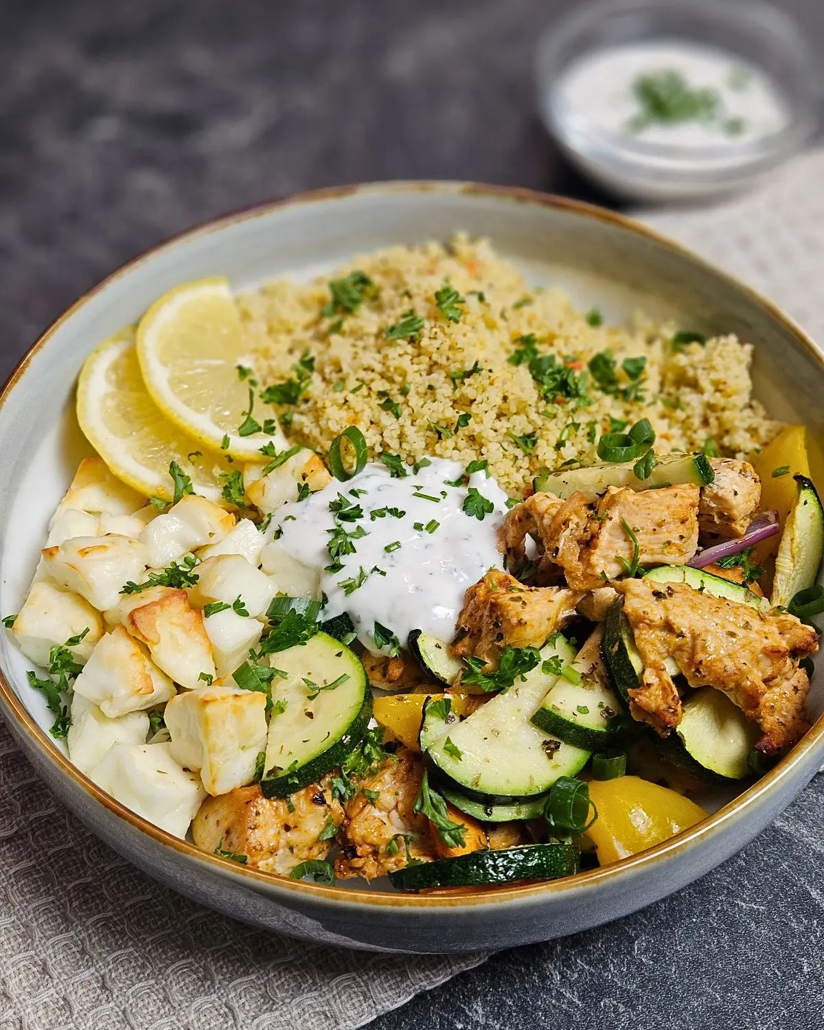 Hähnchen-Halloumi-Bowl mit Couscous in einer Bowl angerichtet