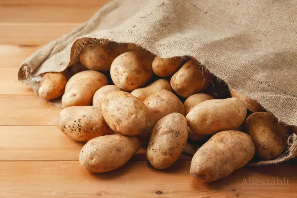 Kartoffeln fallen aus einem Sack auf ein Brett
