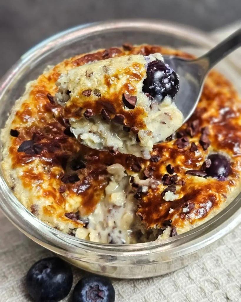 Protein Baked Oats in einer Glasschüssel, mit Heidelbeeren