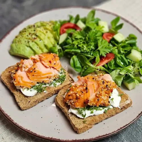 Vollkorntoast mit Lachs und Avocado auf einem Teller angerichtet