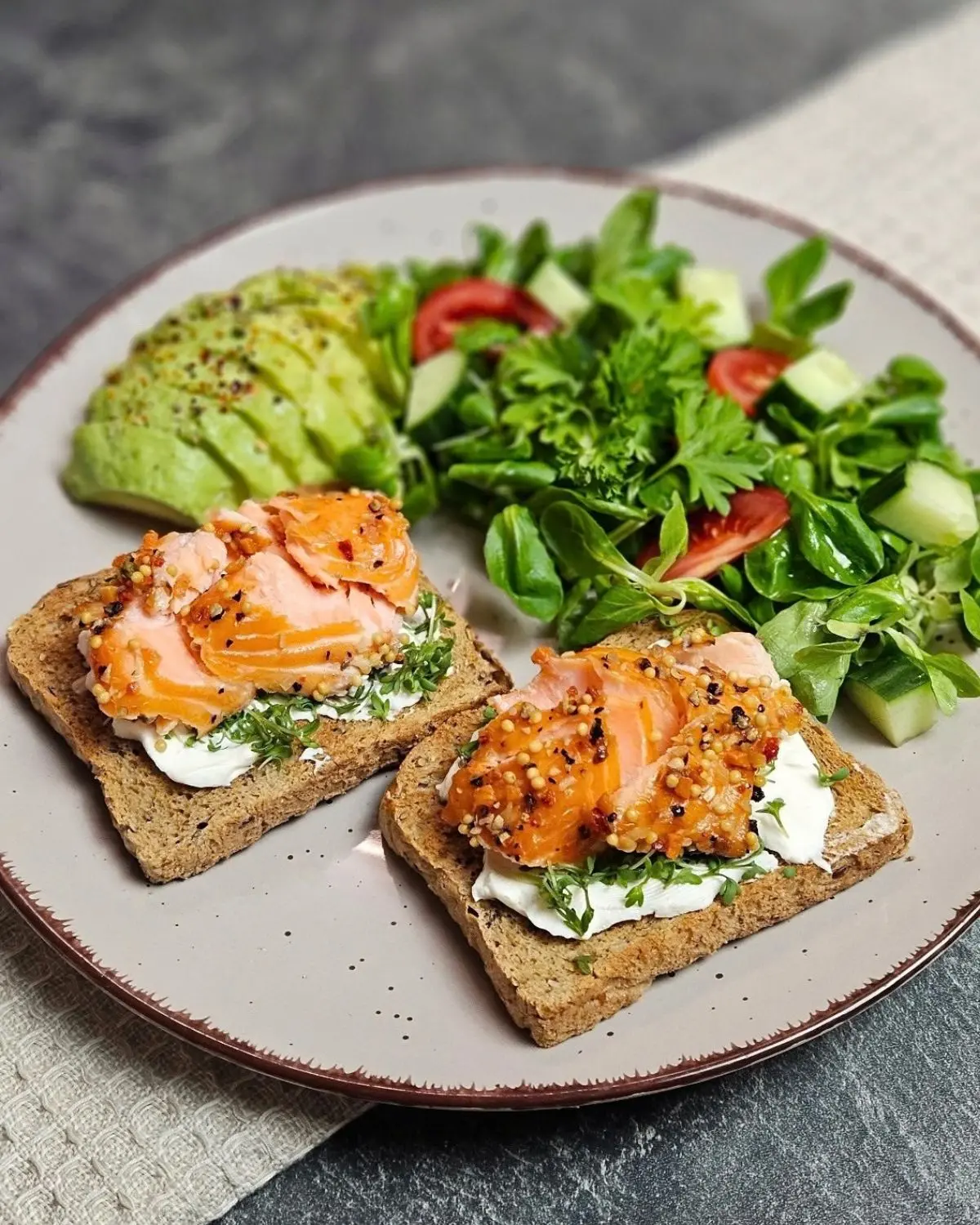 Vollkorntoast mit Lachs und Avocado auf einem Teller angerichtet