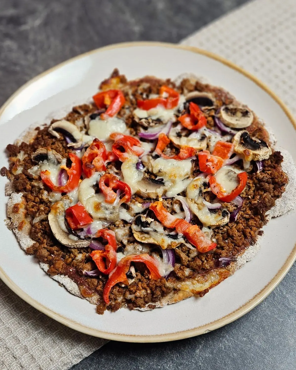 Hackfleischpizza mit Skyr-Teig auf einem Teller angerichtet